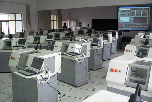 Why do schools buy small desktop-class CNC machines instead of large industrial CNC machines?